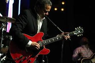 Eddie Martinez photo playing an ES-335 guitar.